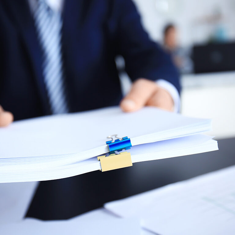 Businessman holding documents in office, closeup